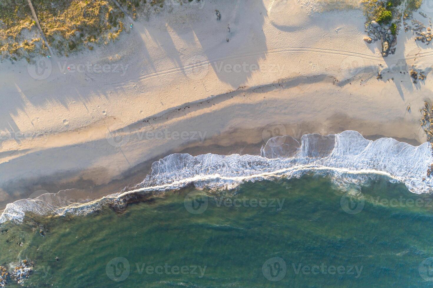 shore of a beach at sunrise, zenithal view with drone photo