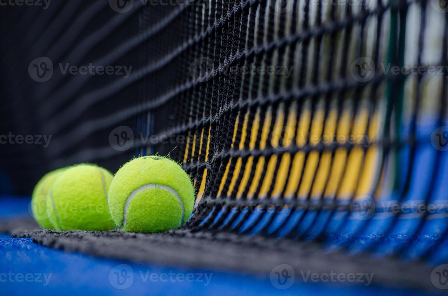 Selective focus. Three balls an the net of a paddle tennis court photo