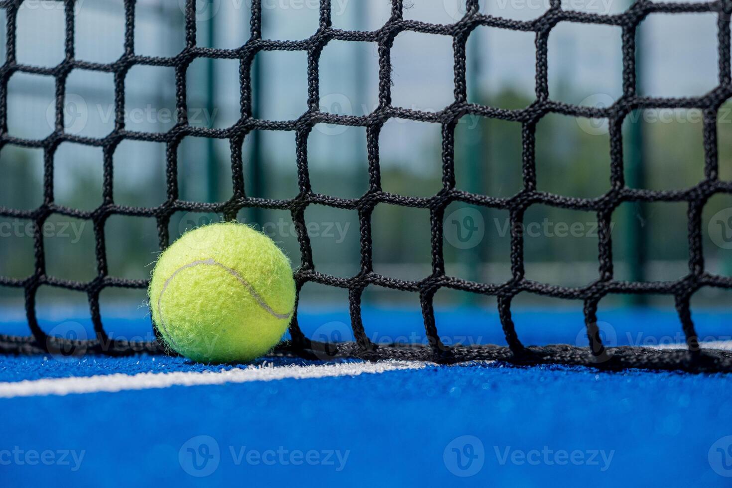 ball at a blue paddle tennis court close to the net photo