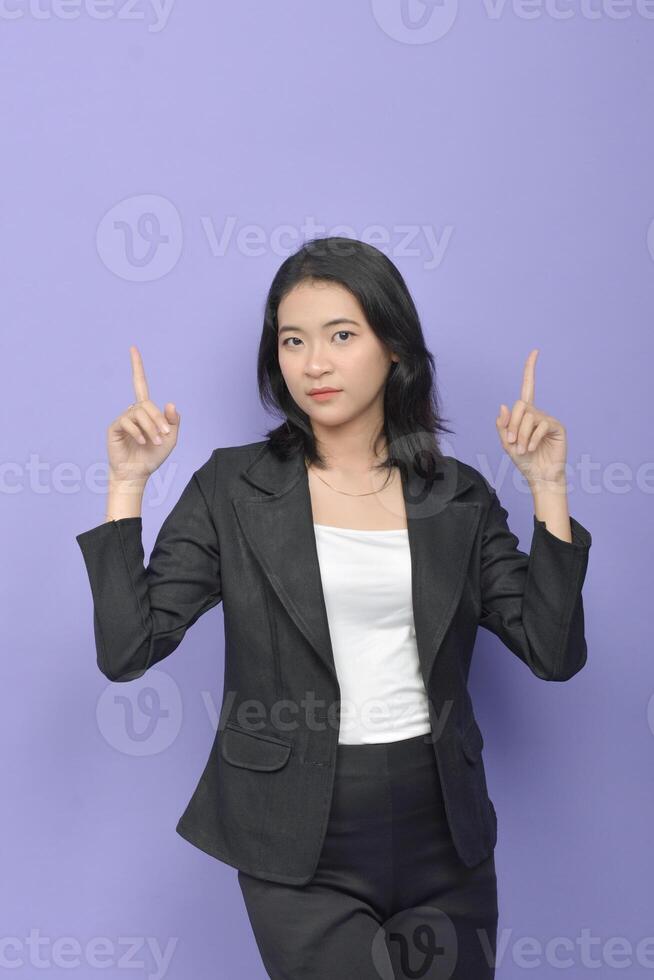 Young asian business woman pointing up on purple background photo