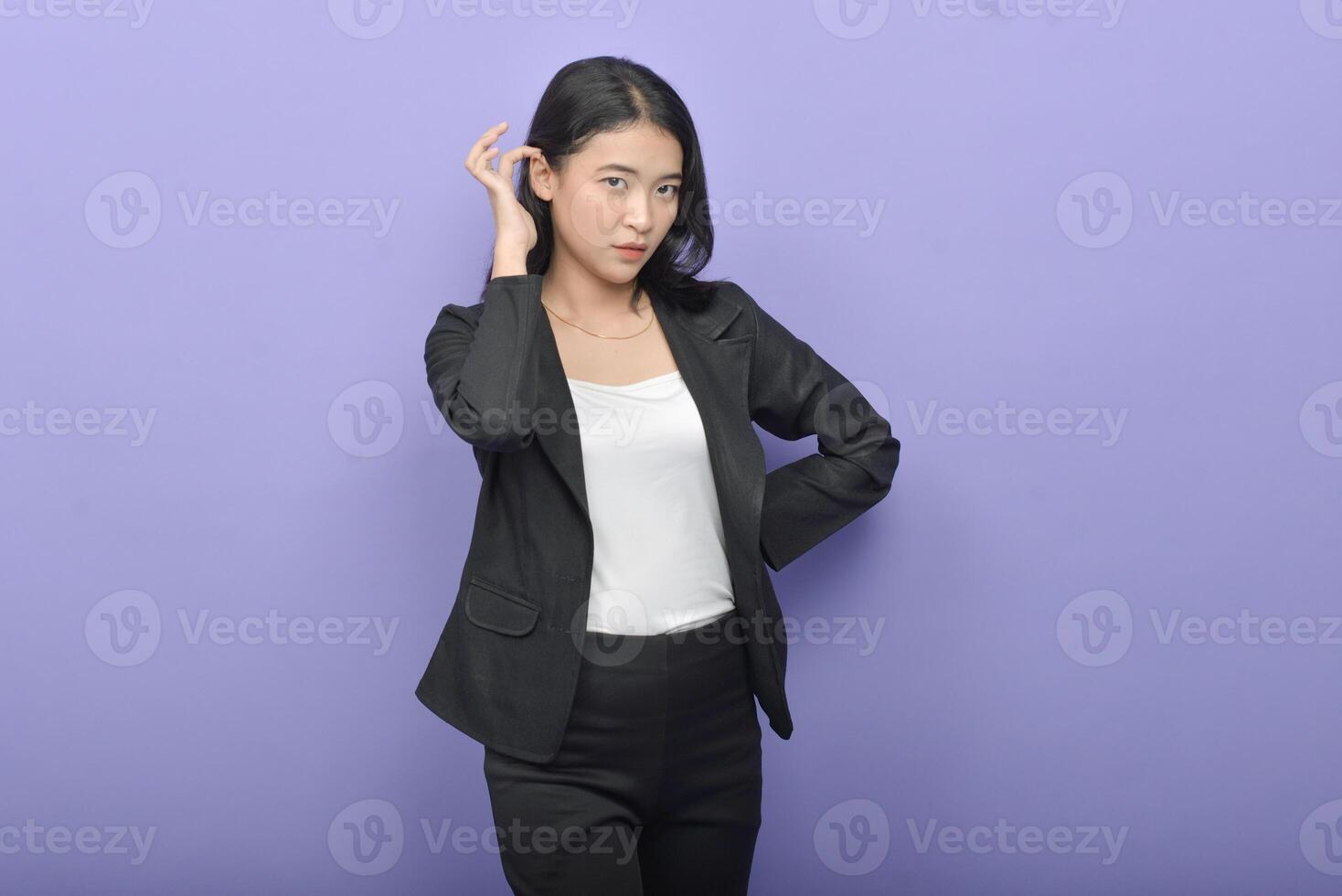 Asian woman in business suit posing against purple background photo