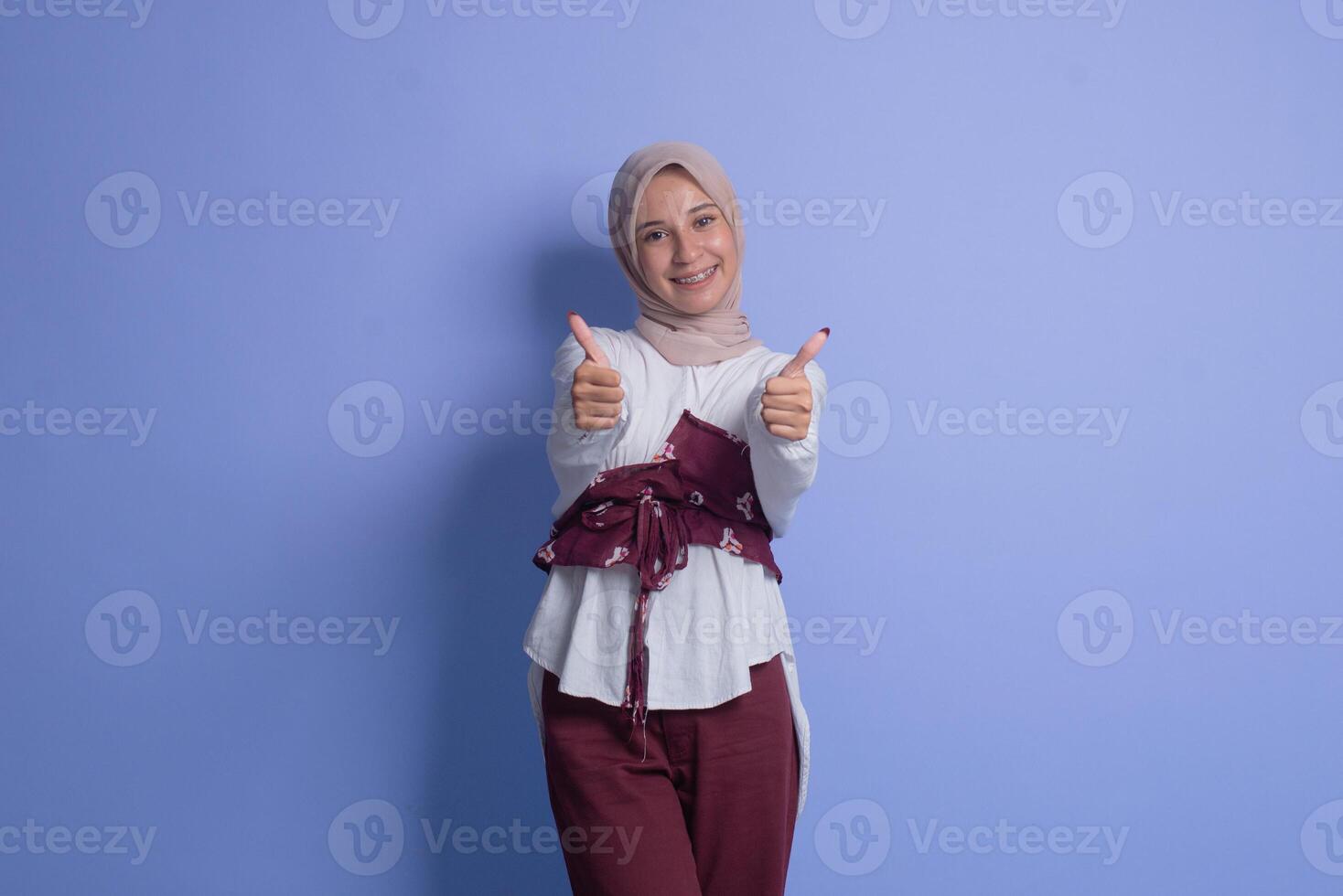 Young muslim woman in hijab showing thumbs up photo