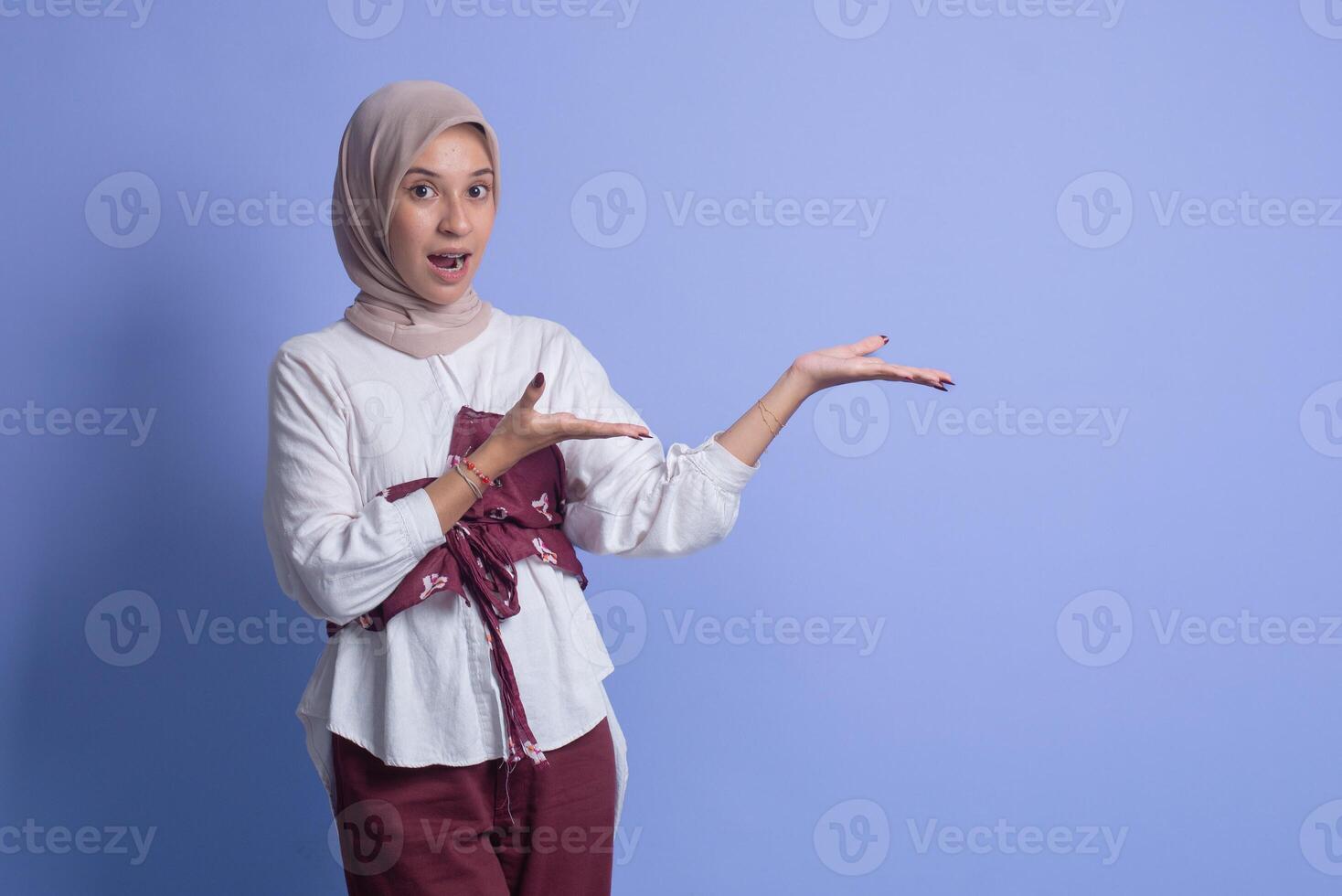 Young muslim woman with hijab on blue background photo