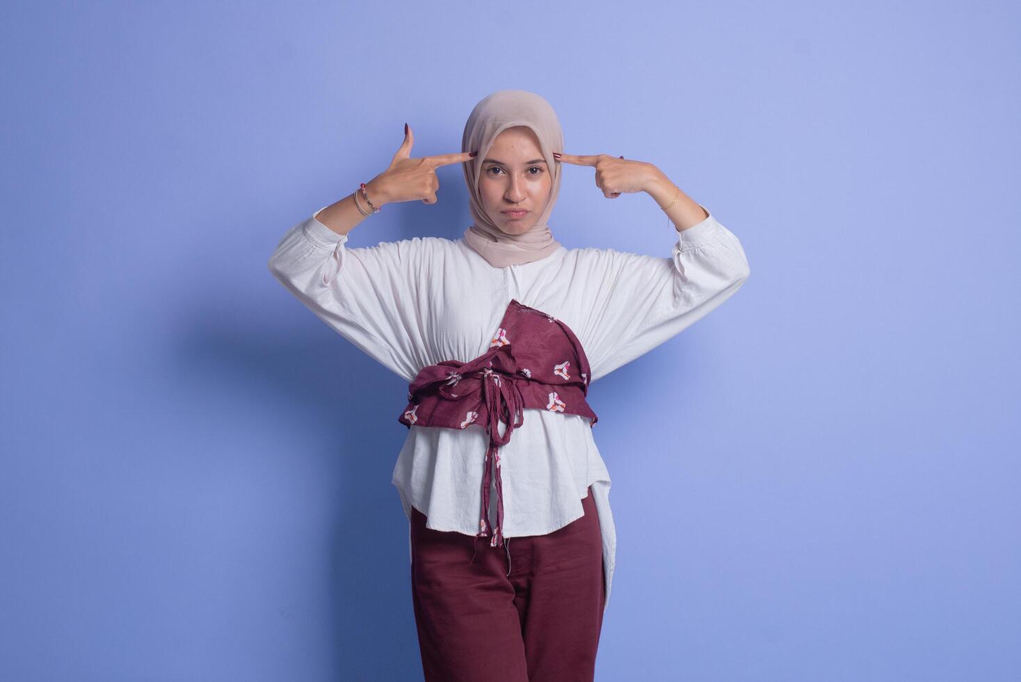 Young muslim woman in hijab holding up two fingers photo