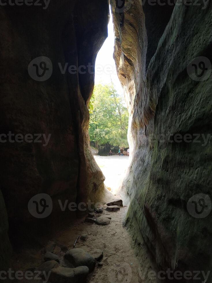 Exploring a sunlit crevice in nature's rock formations under a clear sky photo