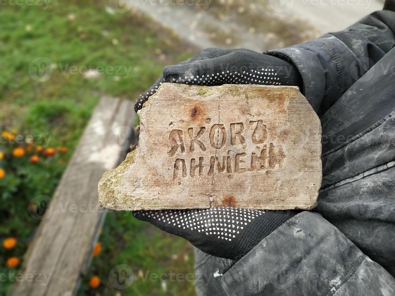 A historical fragment discovered in a quaint village showcasing unique Cyrillic inscription and rustic charm amidst vibrant nature photo