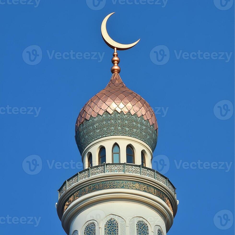 Beautiful mosque minaret topped with a crescent moon against a clear blue sky, showcasing Islamic architecture photo