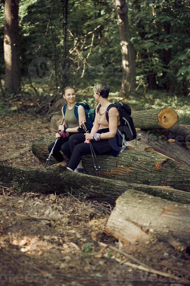 Mother And Daughter Taking A Break While Hiking In The Forest photo