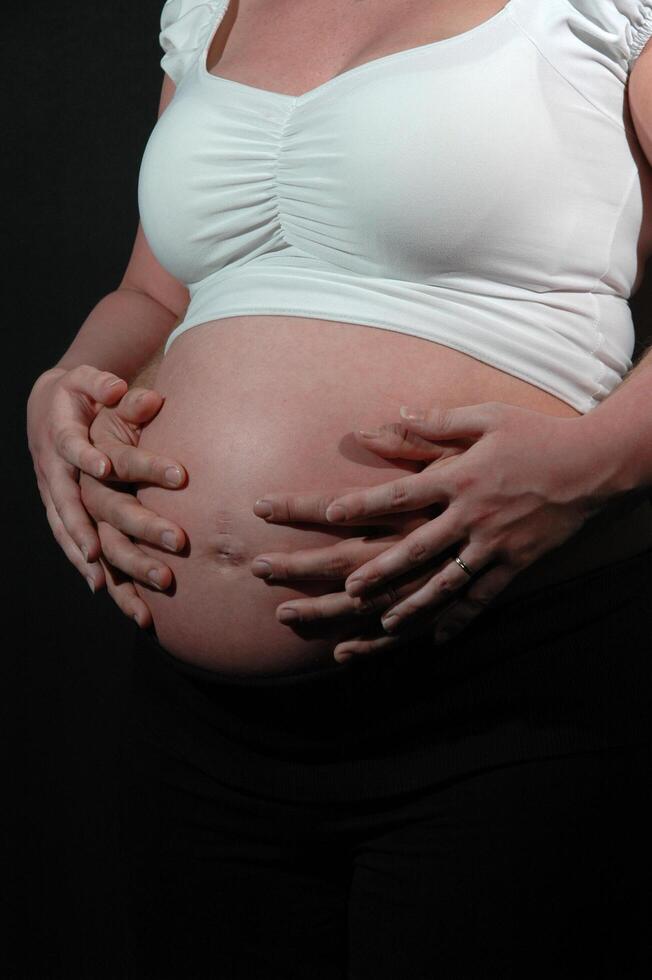Pregnant woman and hands photo