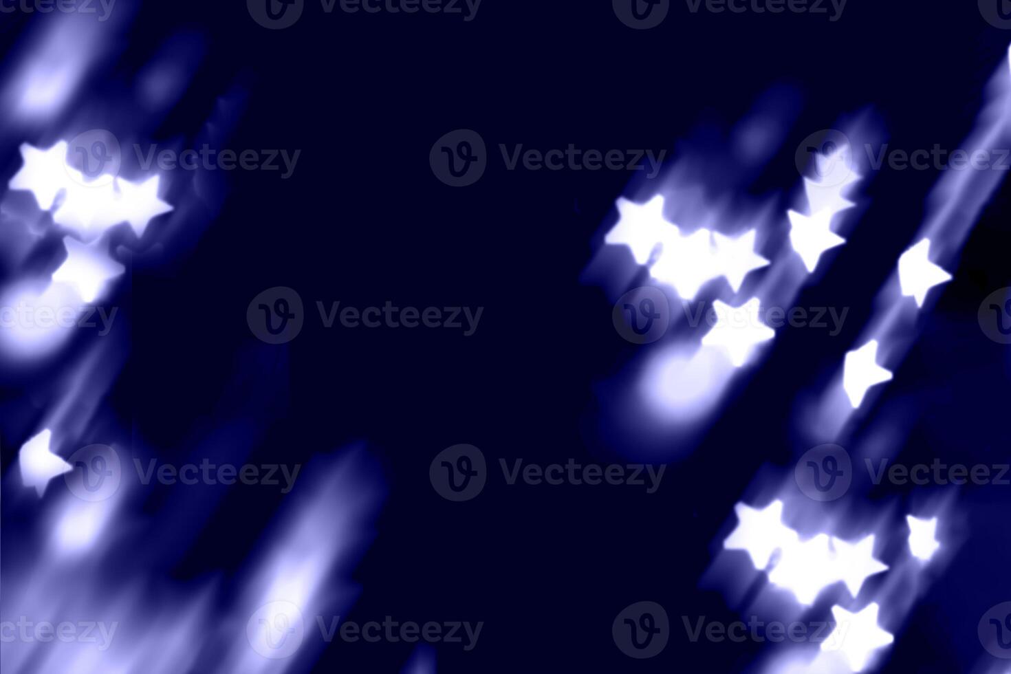 Blurry garland lights on a dark background. Festive Christmas and New Year background. Soft focus photo