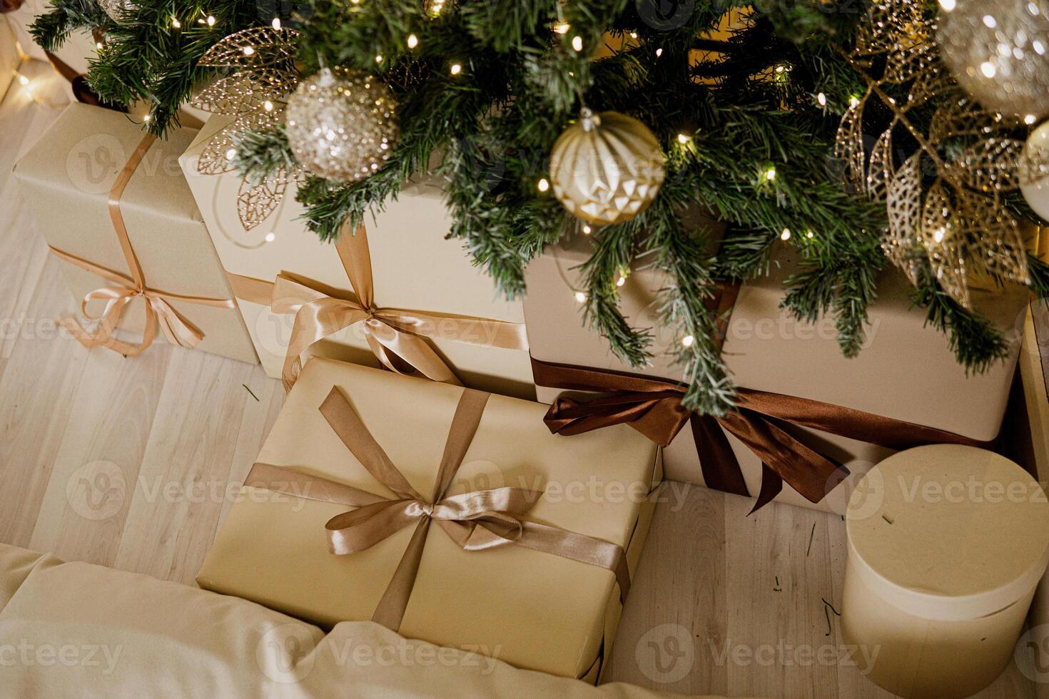 Designer Christmas tree decoration with light decorations. The concept of celebrating New Year and Christmas. Gifts in craft packaging under the Christmas tree photo