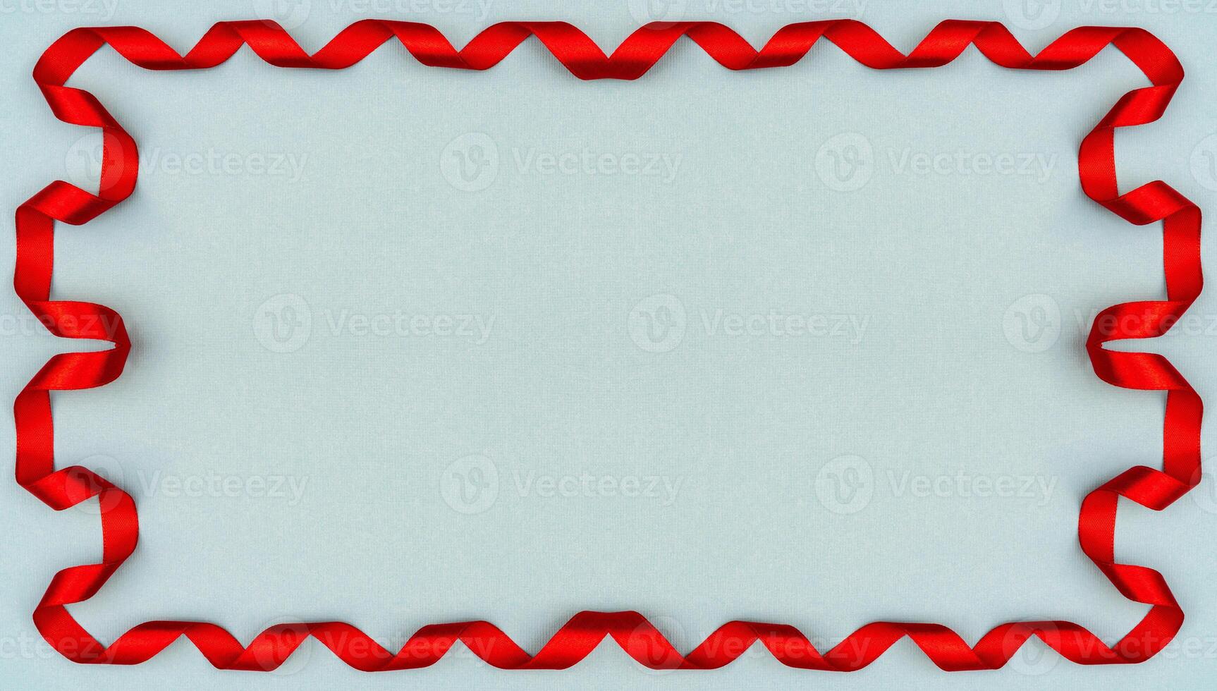 Red wavy ribbon on blue background. Holiday decoration. Valentine's Day decoration congratulation frame. photo