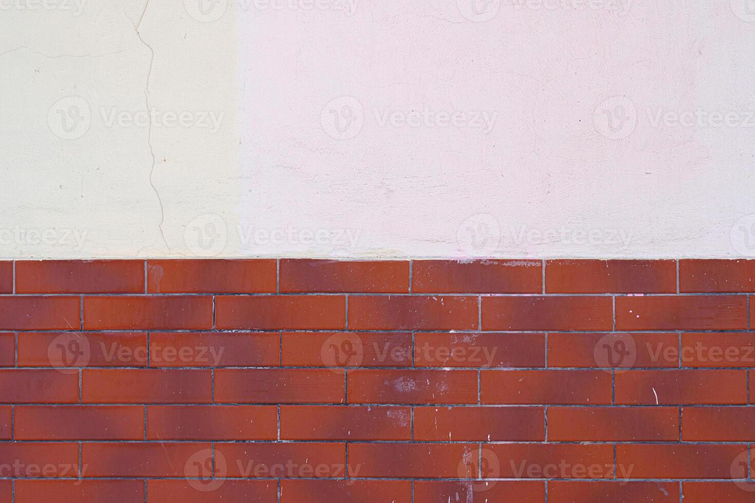 Half of the red brick wall is painted over with white plaster. Abstract construction background. photo