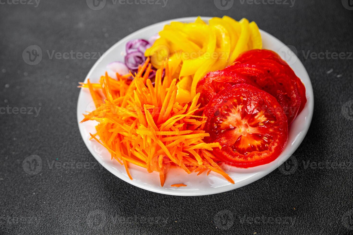 salad fresh vegetables cut into a plate tomato, carrot, pepper, onion juicy fresh gourmet food background on the table rustic food top view copy space keto and paleo diet Vegetarian and vegan photo