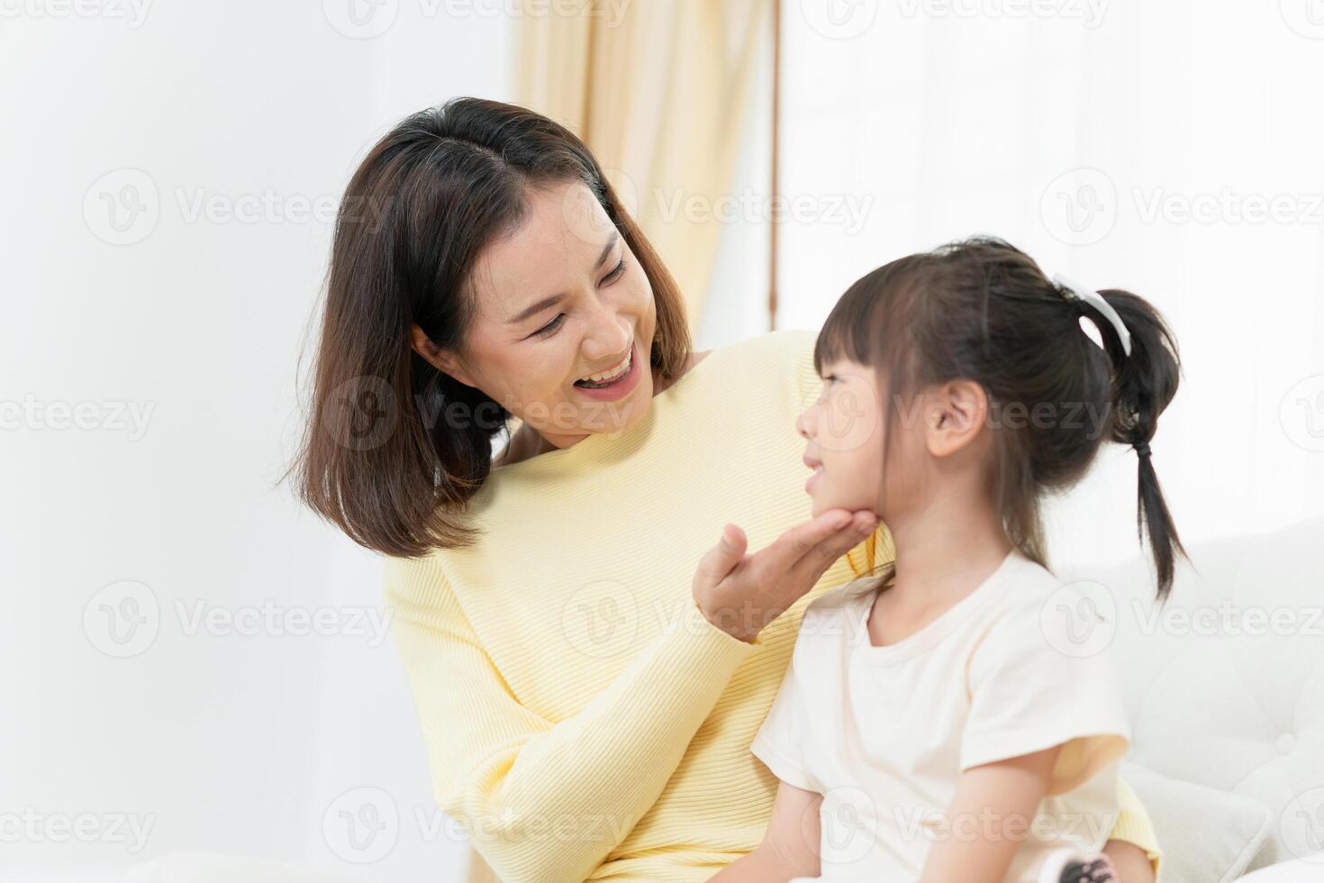 Asian mother enjoying with daughter in living room at home photo