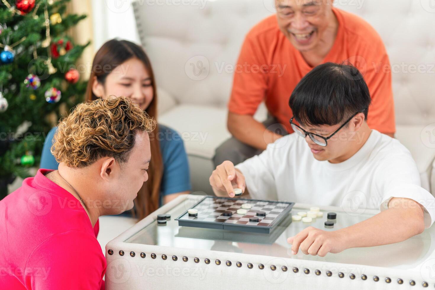 Asian friends playing a game of checkers at home, Senior man with grandchild relaxing together at home photo