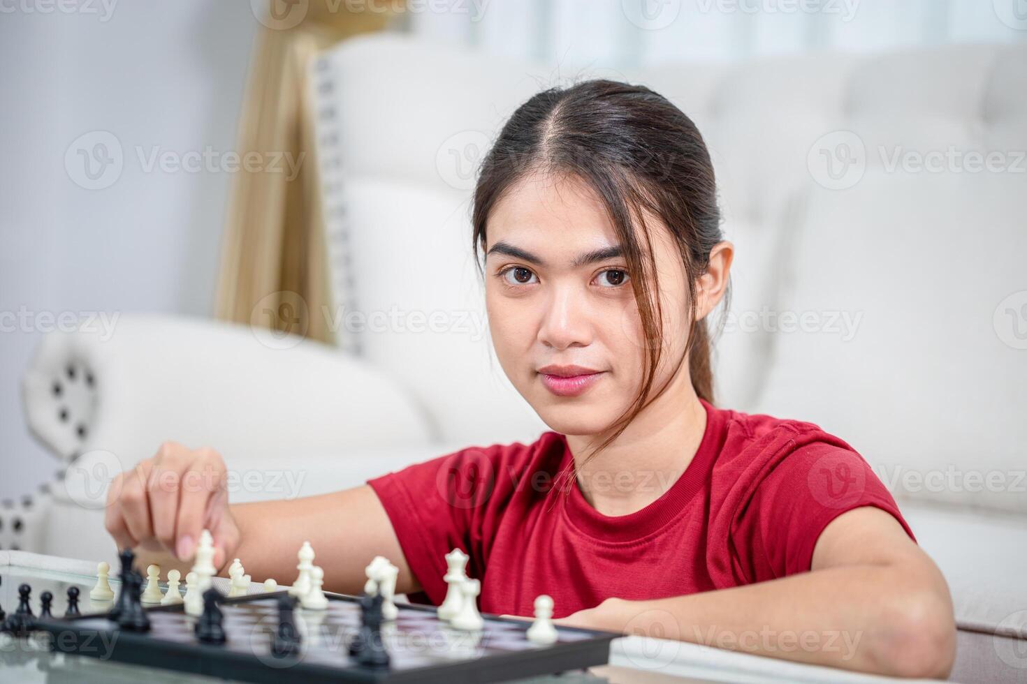 Asian woman playing a game at home, Close up of Woman moving chess, Asian woman plays chess in living room photo