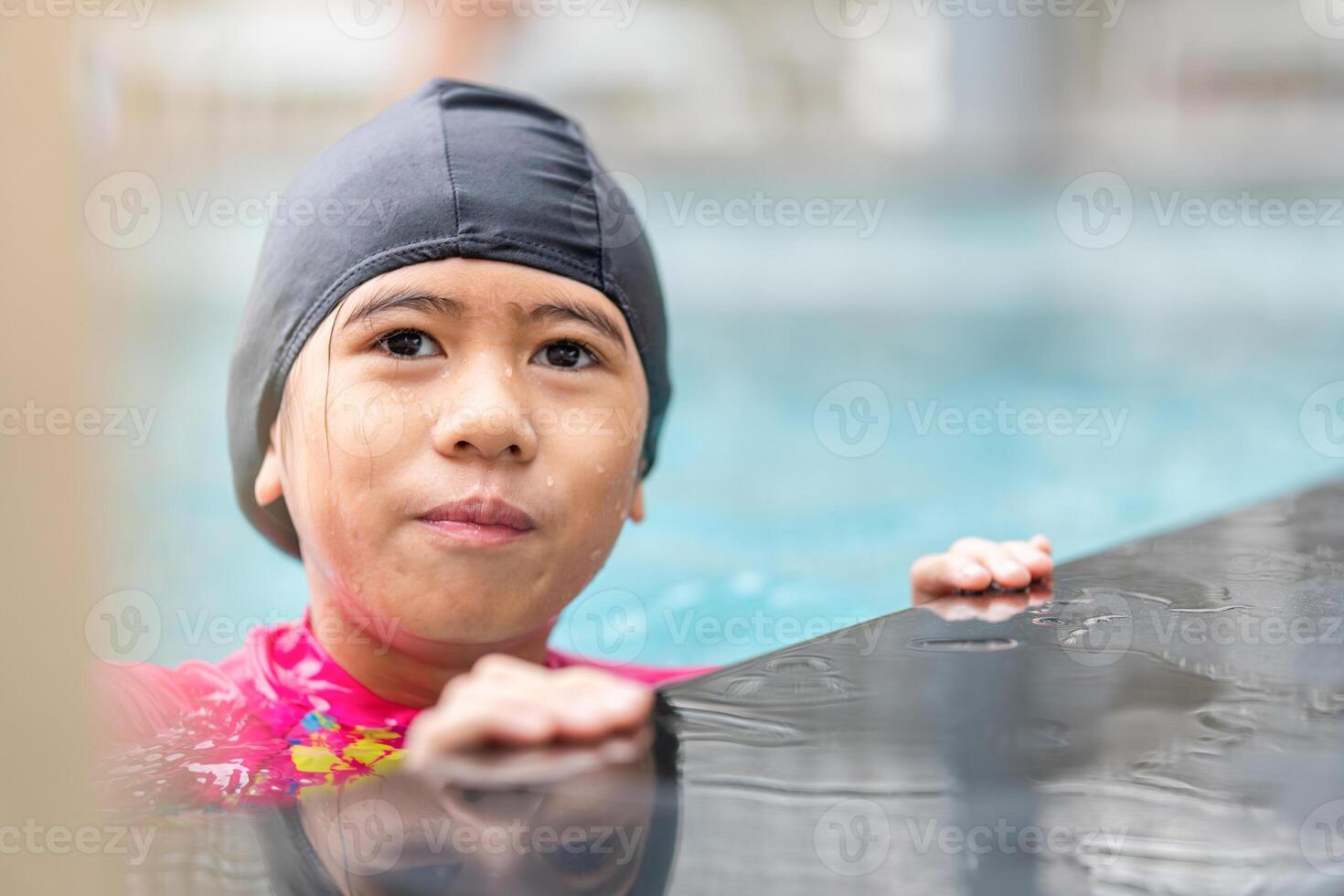 Asian kids girl playing and having fun in swimming pool, Asian children in swimsuit playing in swimming pool photo
