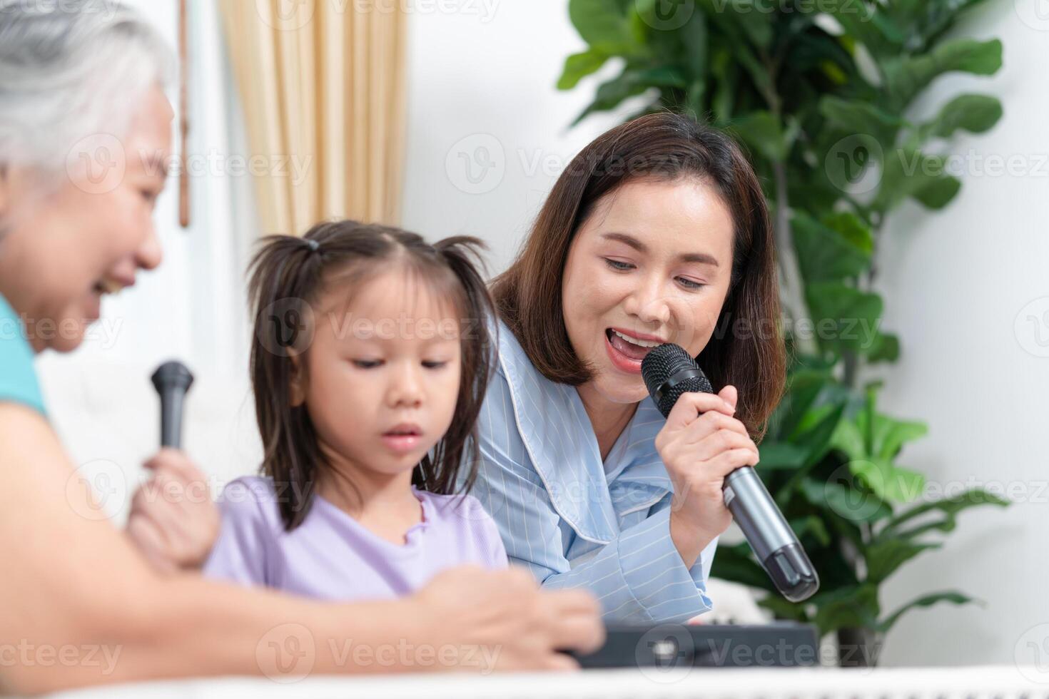 Grandparents and grandchild having fun together while singing and playing board game in living room at home photo
