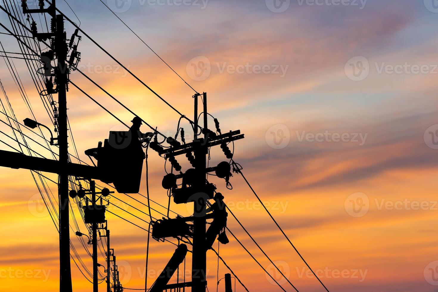 Silhouette of Electrician officer climbs a pole and uses a cable car to maintain a high voltage line system, Shadow of Electrician lineman repairman worker at climbing work on electric post power pole photo