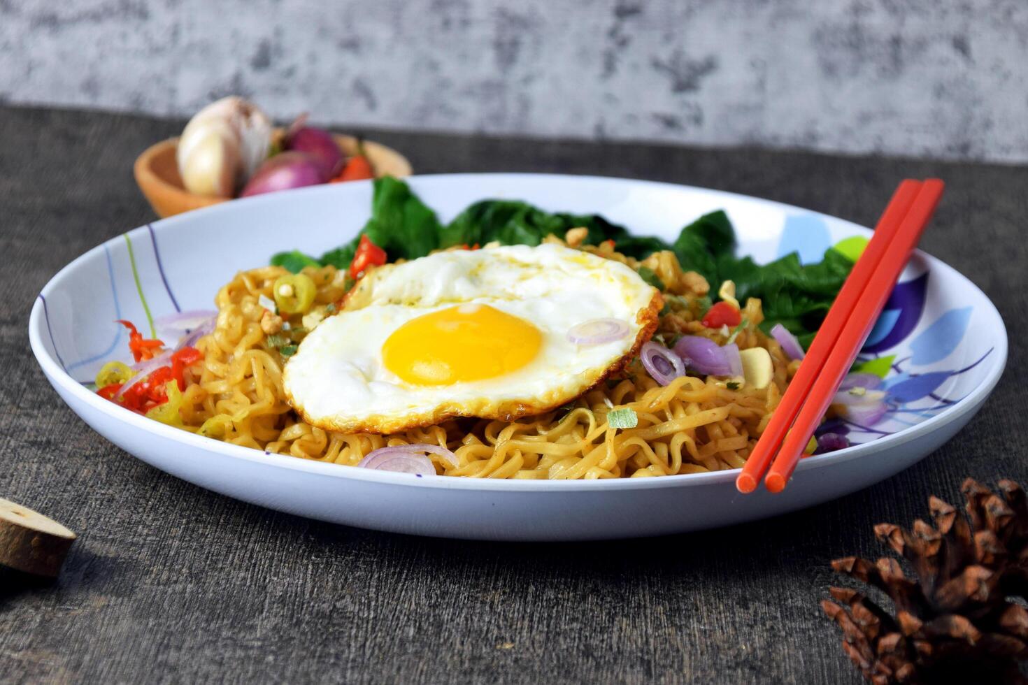 Closeup photo of fried noodles with sunny side up egg and mixed vegetables