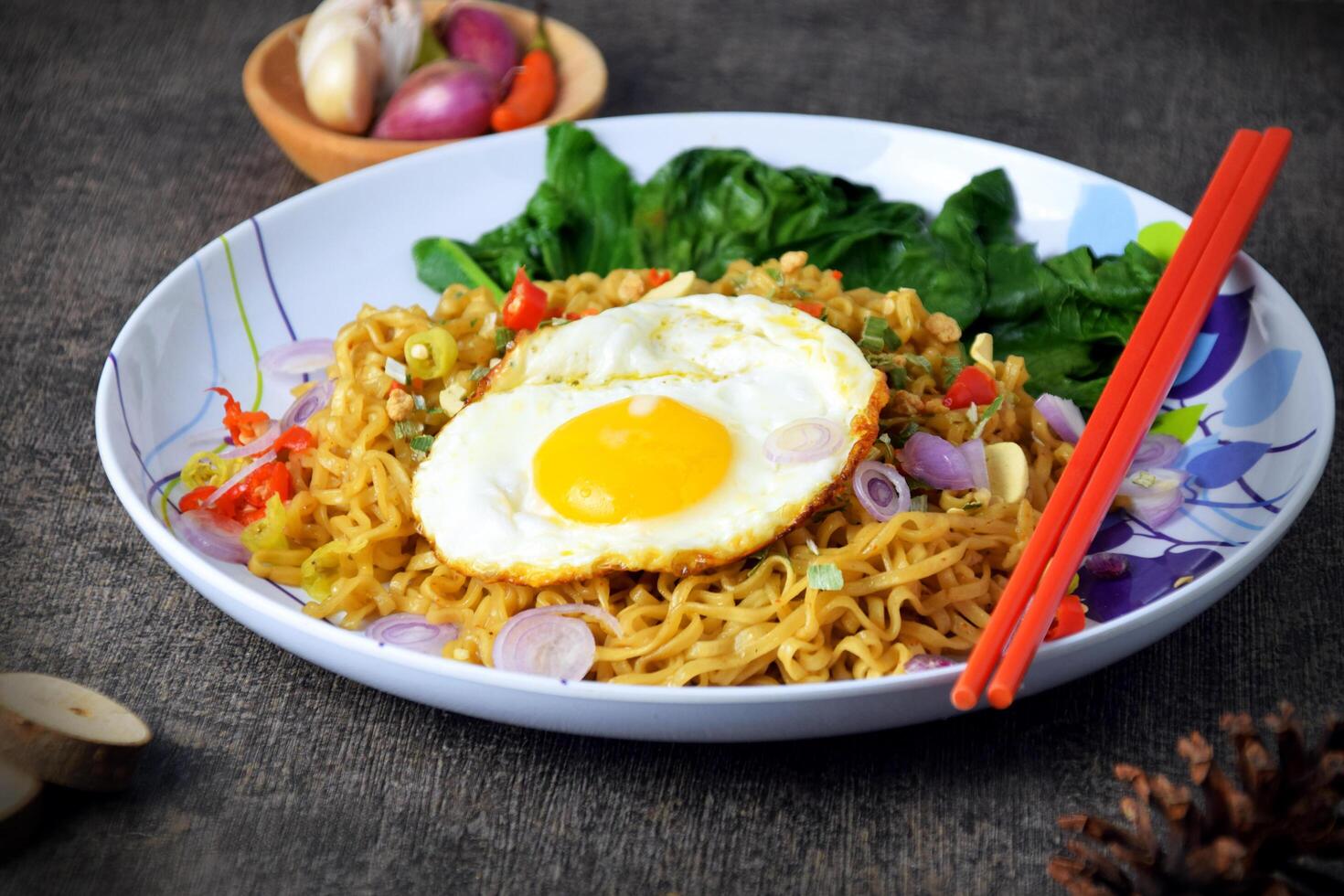 Closeup photo of fried noodles with sunny side up egg and mixed vegetables