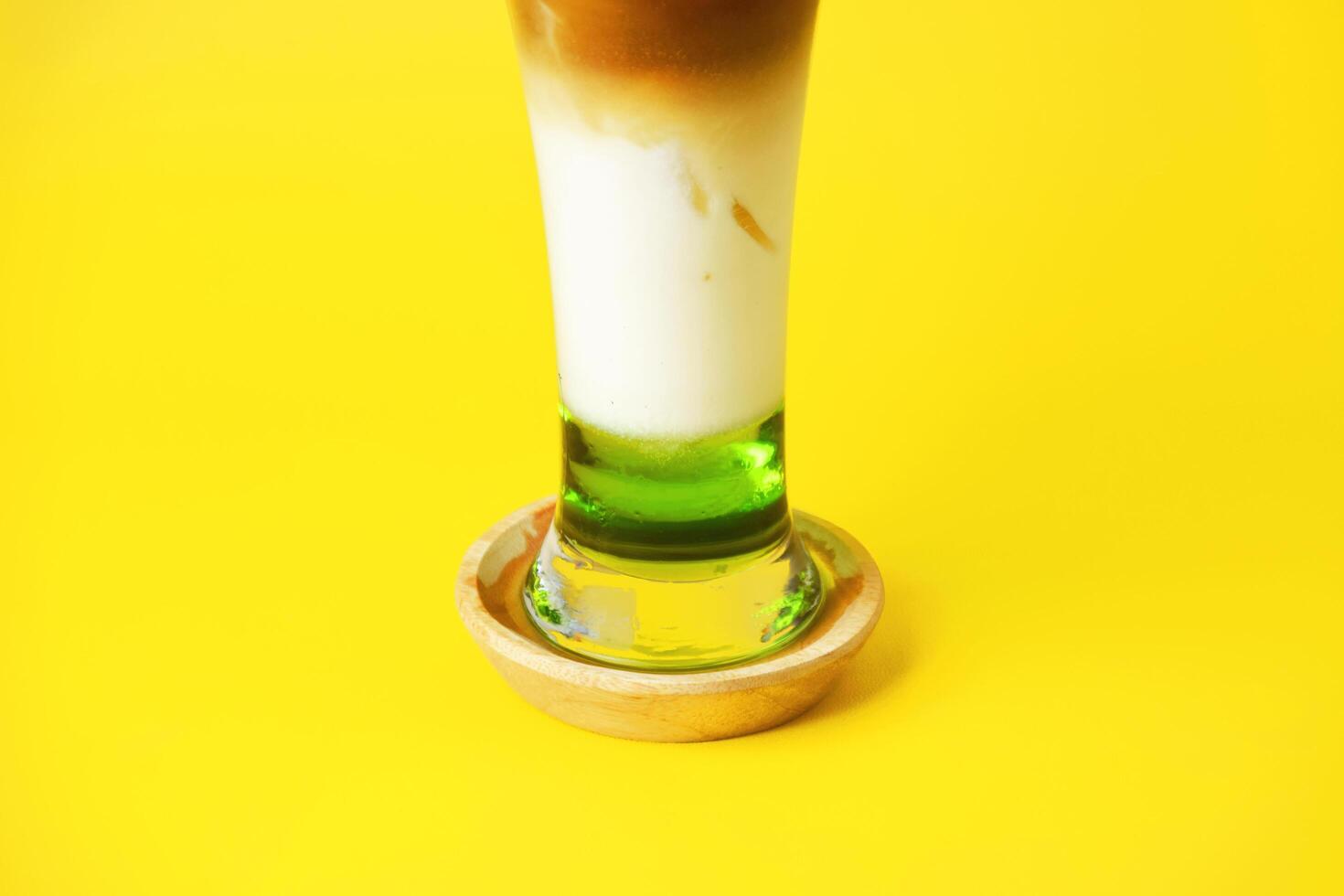 Closeup photo of an iced coffee drink layered with melon syrup, milk and coffee