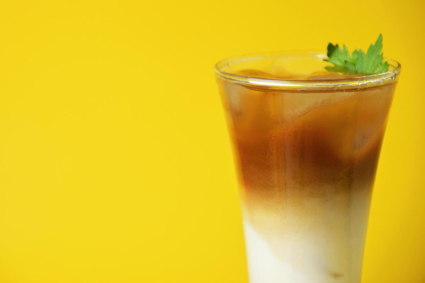 Closeup photo of an iced coffee drink layered with melon syrup, milk and coffee