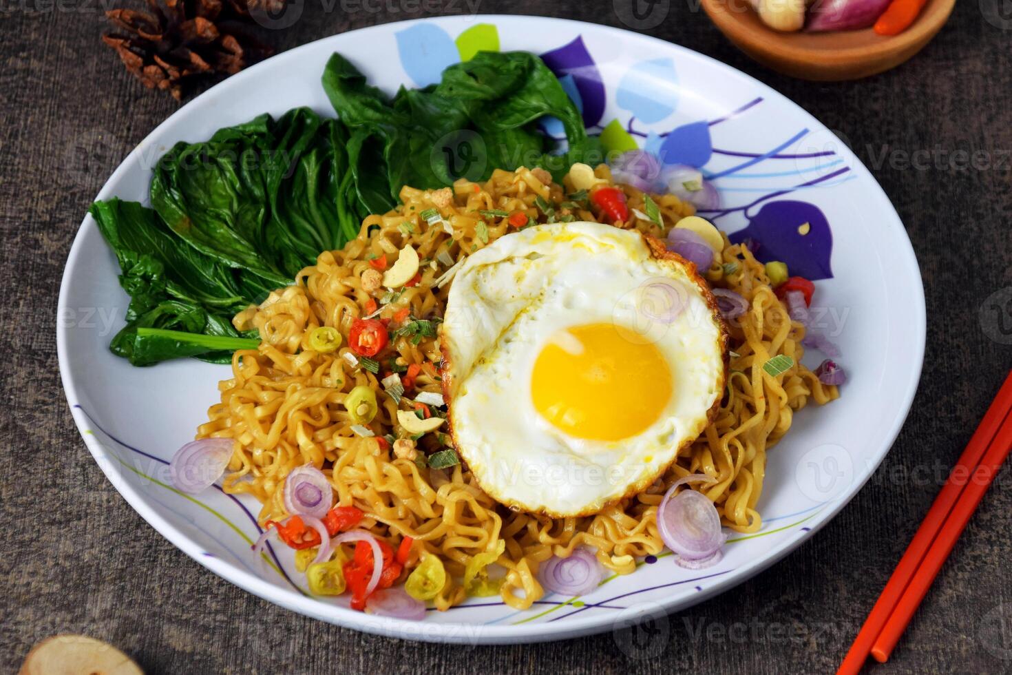 Closeup photo of fried noodles with sunny side up egg and mixed vegetables