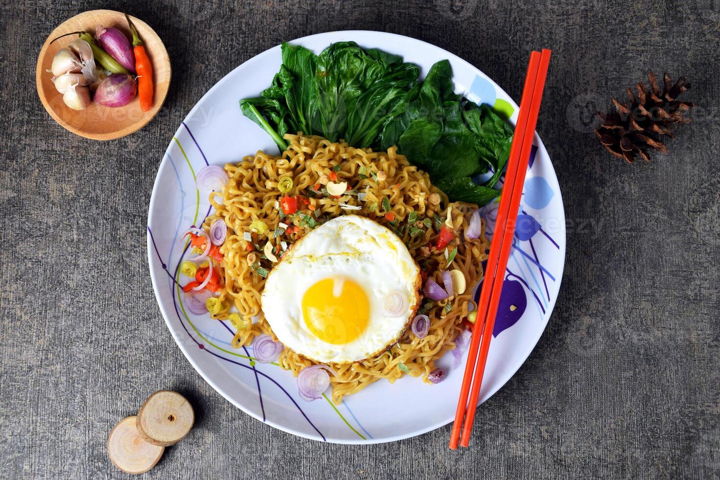 Top view photo of fried noodles with sunny side up egg and mixed vegetables