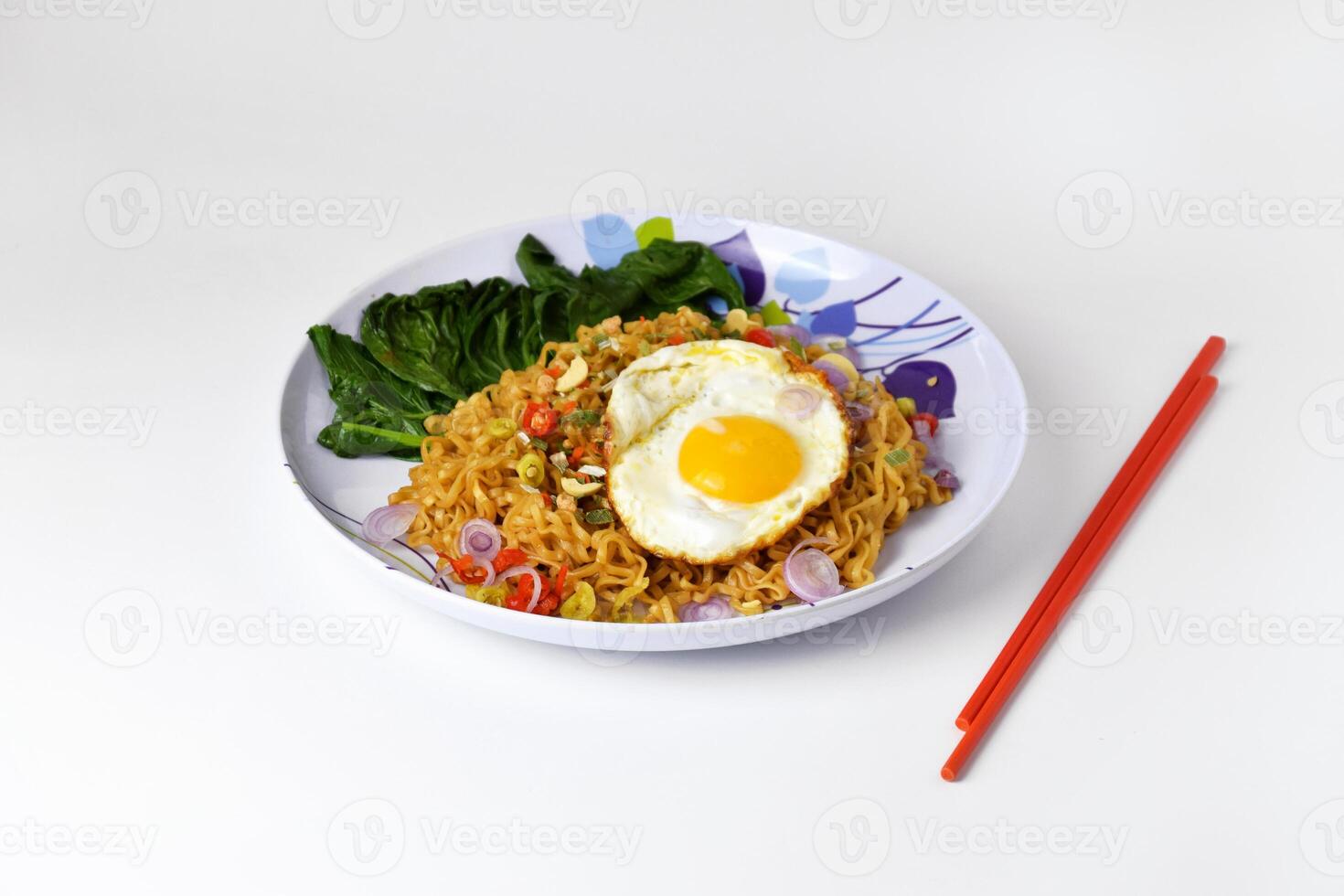 Fried noodles with sunny side up egg and mixed vegetables on a plate photo