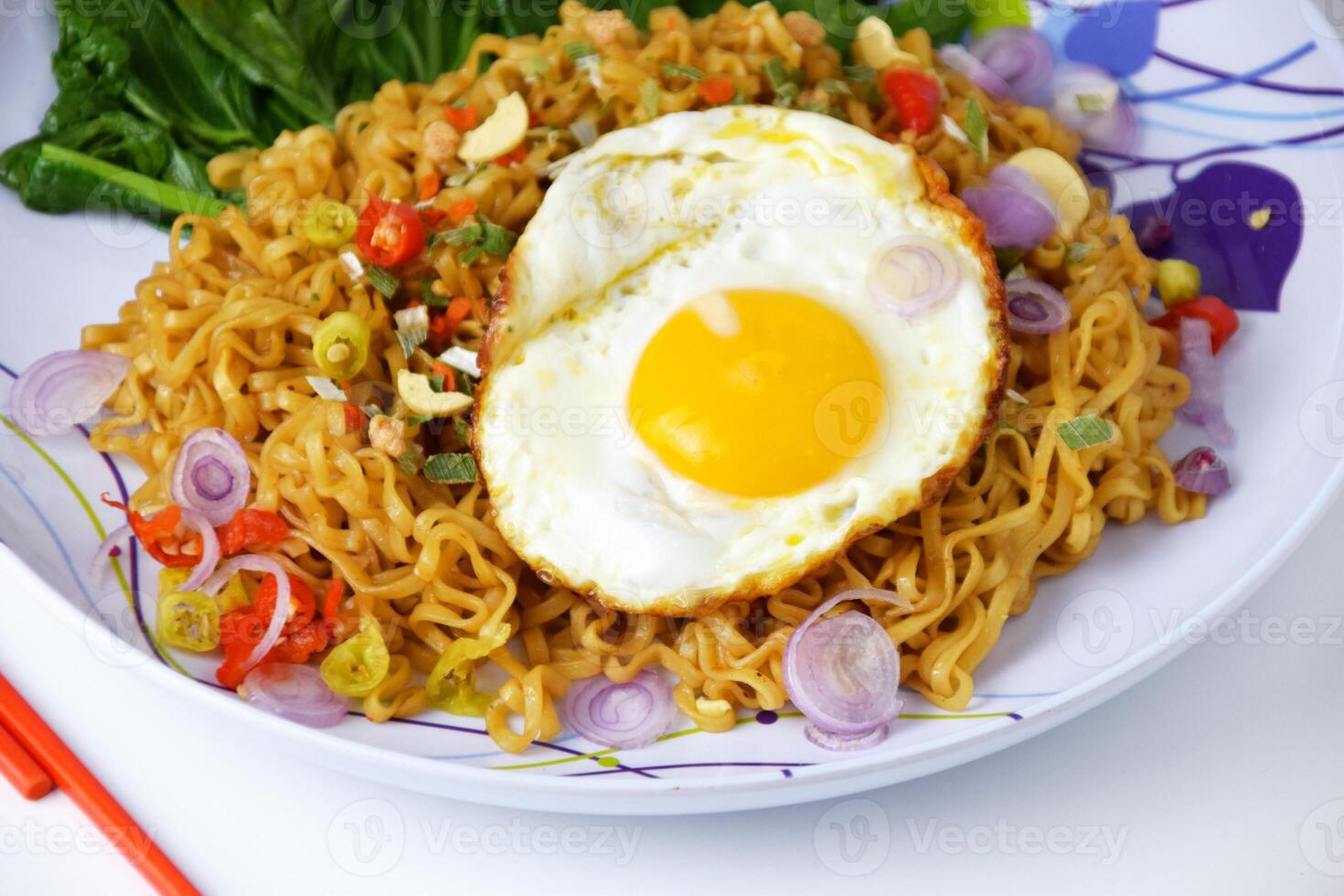 Closeup photo of Fried noodles with sunny side up egg on a plate