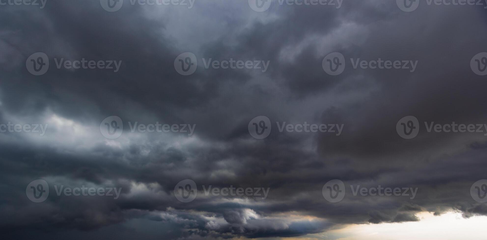 The dark sky with heavy clouds converging and a violent storm before the rain.Bad or moody weather sky and environment. carbon dioxide emissions, greenhouse effect, global warming, climate change. photo