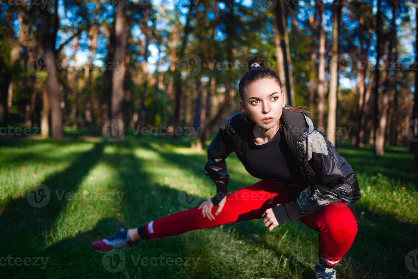 Fit woman stretching in forest setting photo