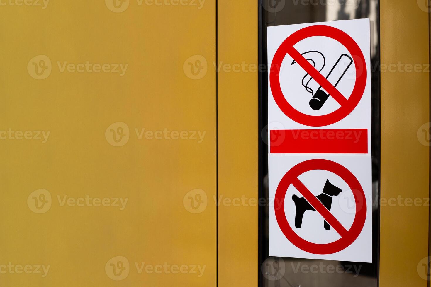 Signs prohibiting smoking and entry into building with dogs. Restricted area with no access for pets. Crossed out cigarette and dog on sticker on building door photo