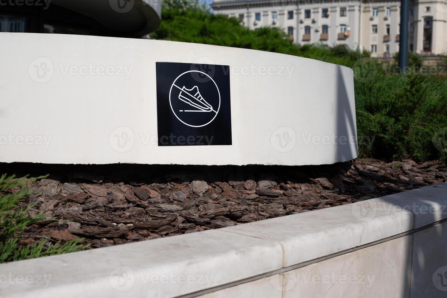 Do not tread on surface, sign with shoes crossed out prevents walking on park decorations, restricted traffic area for people photo