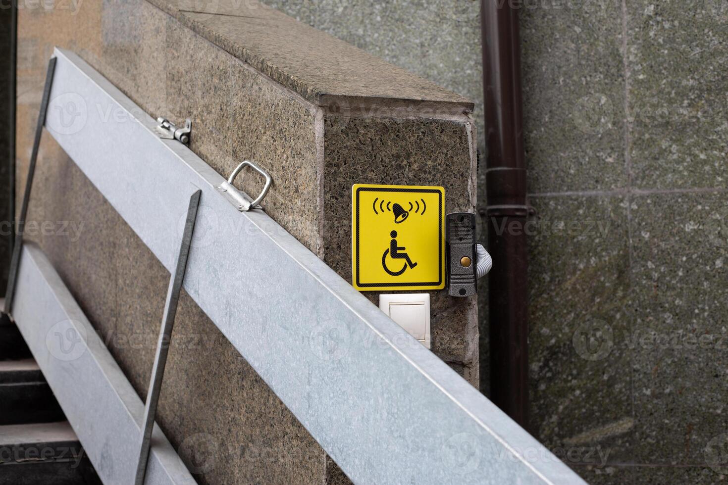 Yellow icon with call button for the disabled people for lifting, convenience for wheelchair users while walking in city, folding ramp for disabled people on narrow stairs photo