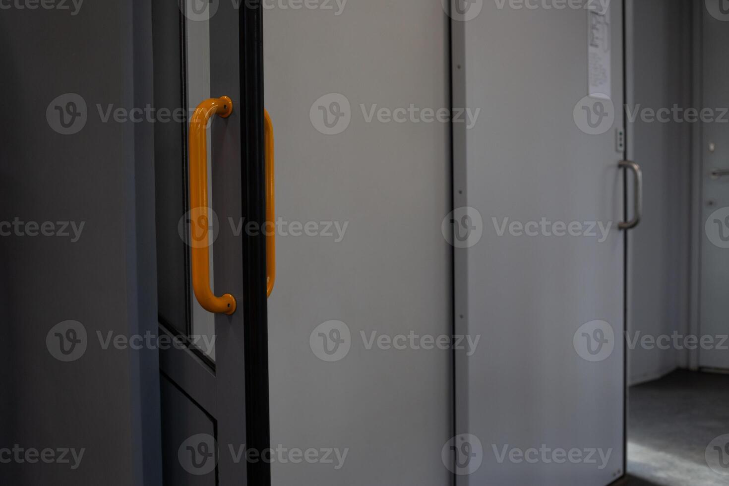 Open passage in train with sliding door, passage to compartment on electric train with door with orange handle, convenience in public transport photo