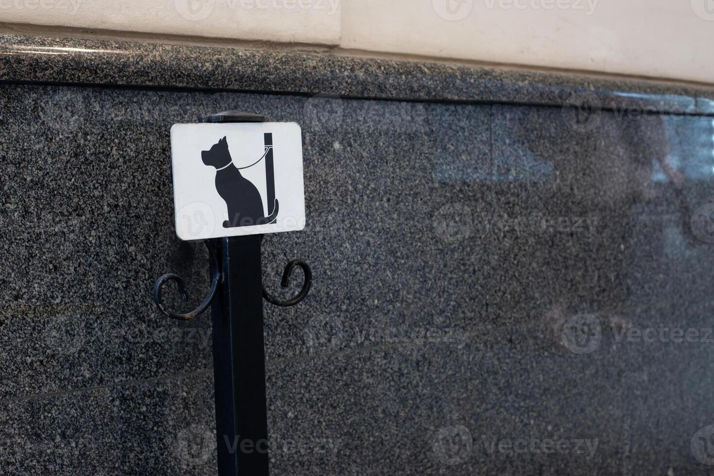 Tie the dog with leash to post to wait for owner outside. Pole to secure pet from escaping in public place, safe condition for waiting for dog in city photo