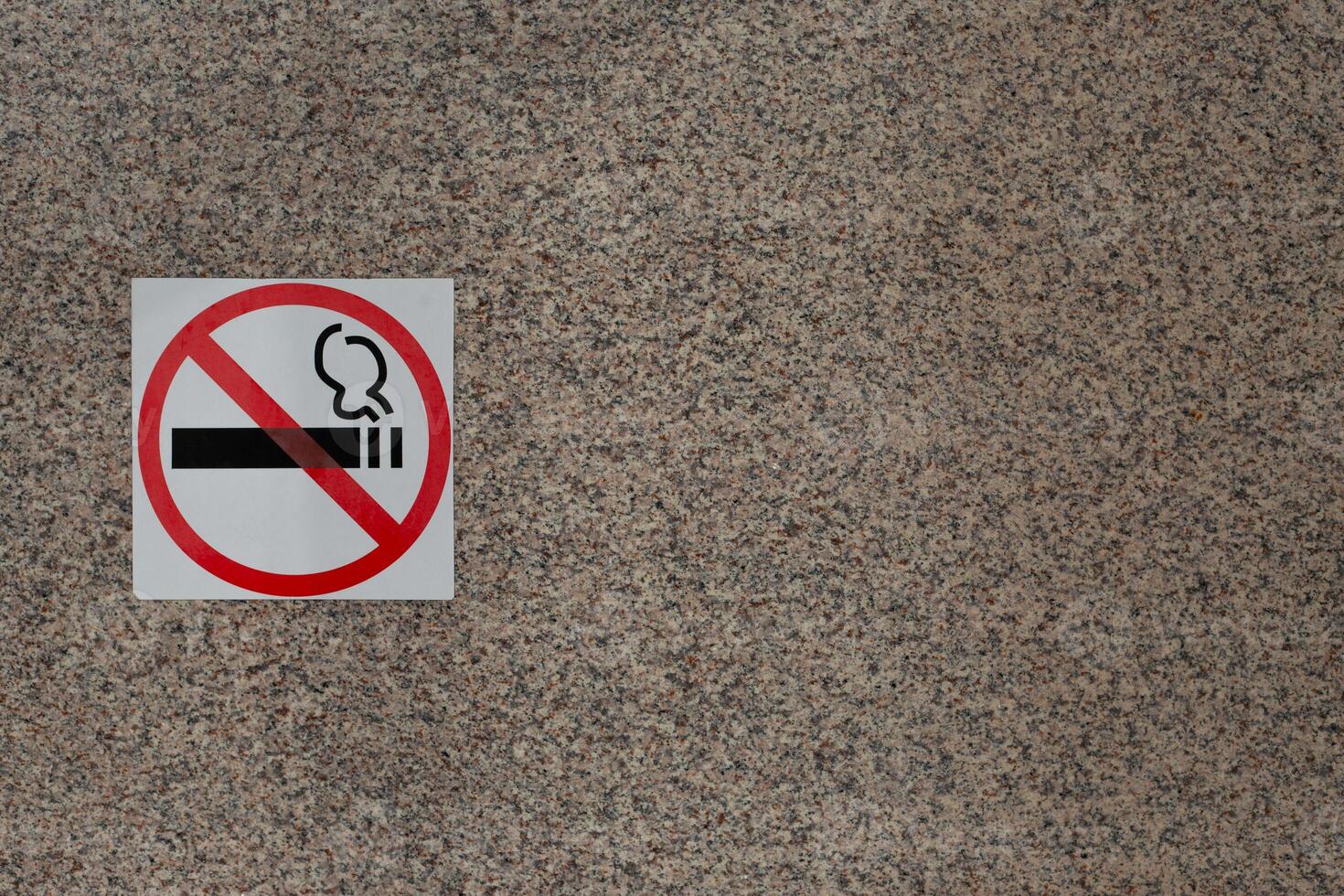 Sign prohibiting smoking in public place on wall of building, smoking ban, sticker indicating smoking free zone, social problem of smoking and fight against bad habits of people photo