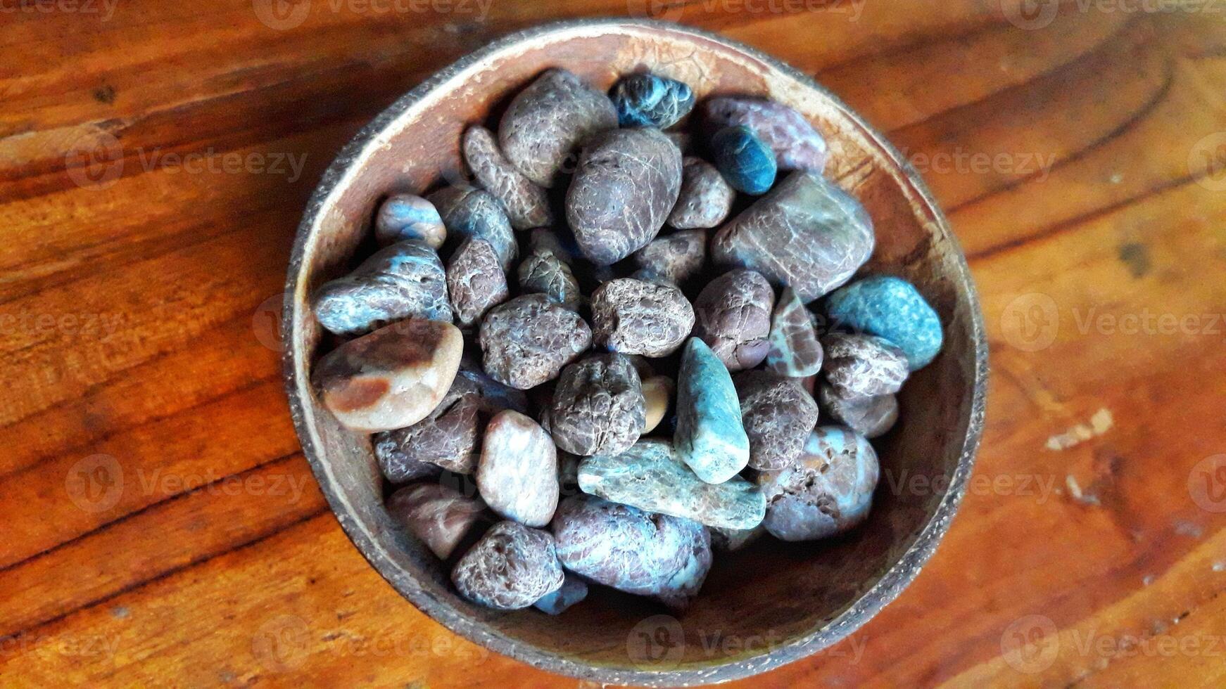 A bowl filled with rocks on a wooden table photo