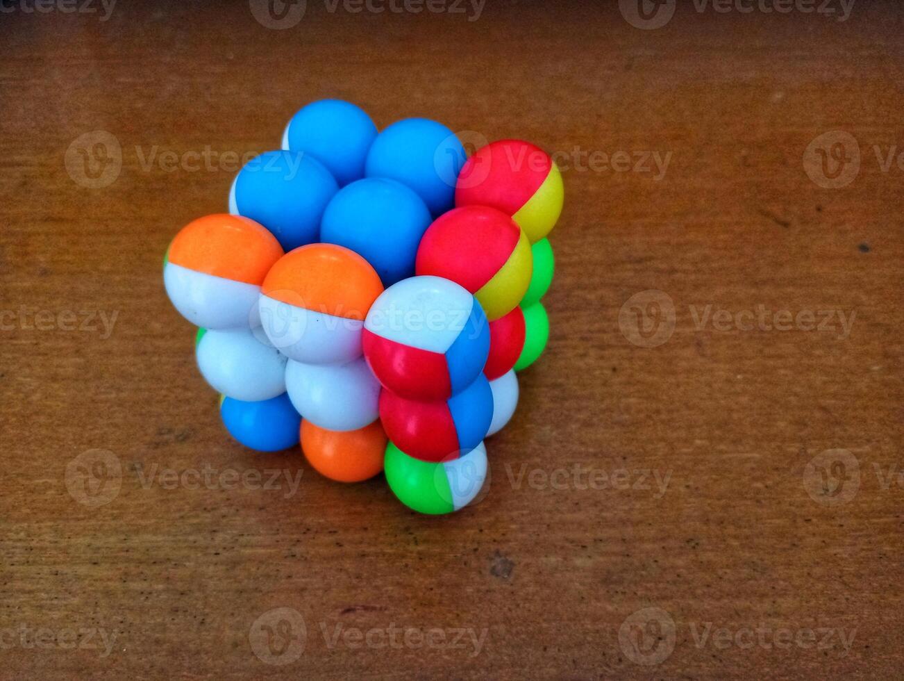 A colorful cube with many different colored balls on it photo
