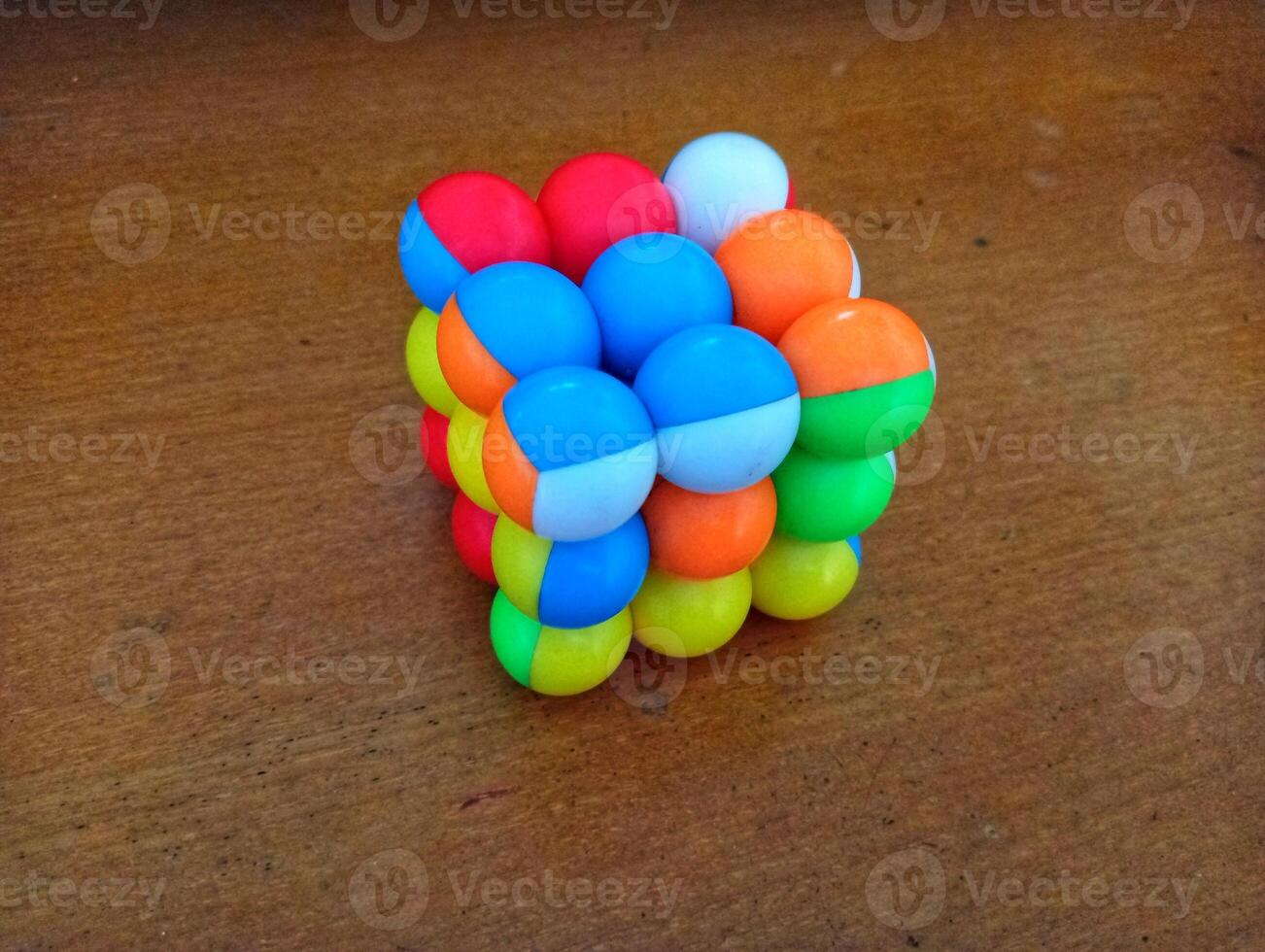 A colorful cube with many different colored balls on it photo