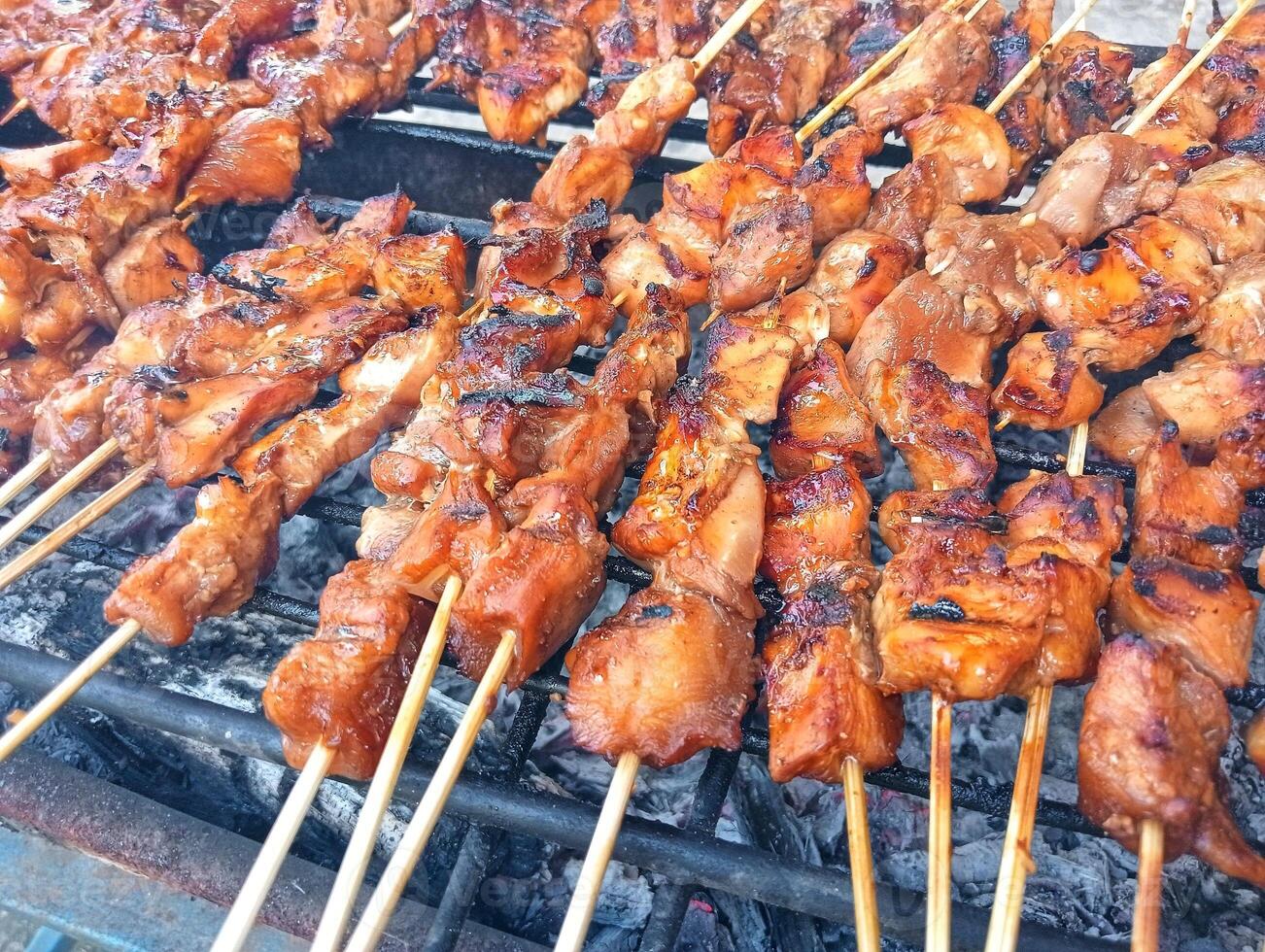 A grill with many skewers of meat on it photo