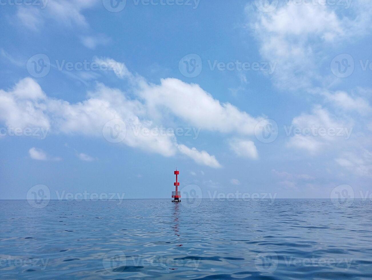 A red buoy in the middle of the ocean photo