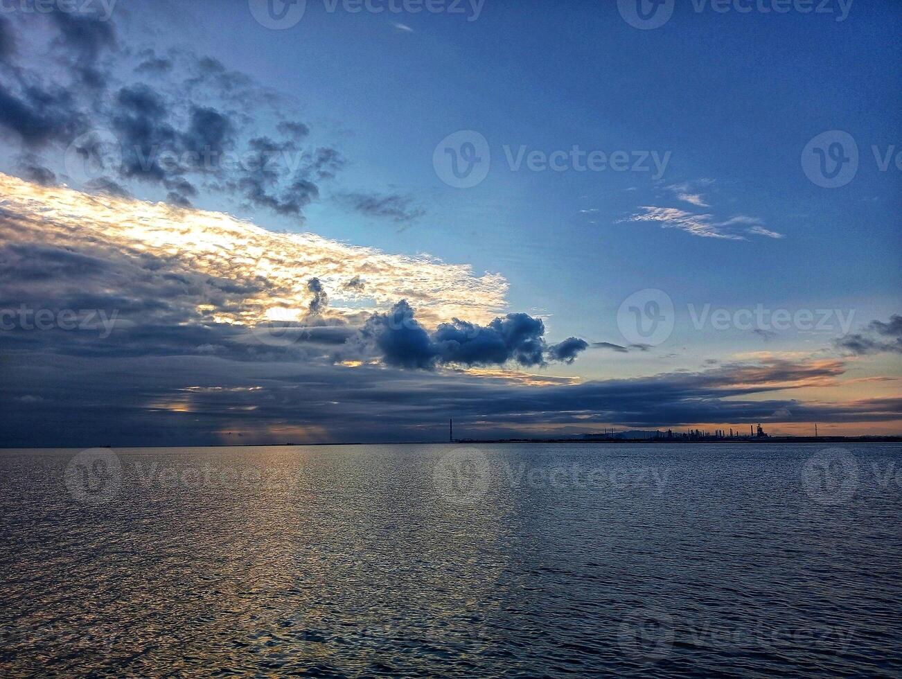 A boat is in the water with a cloudy sky photo