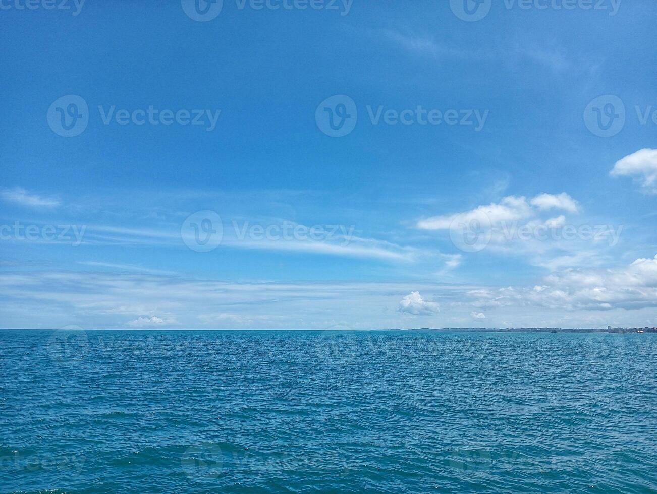 A blue sky with clouds over the ocean photo