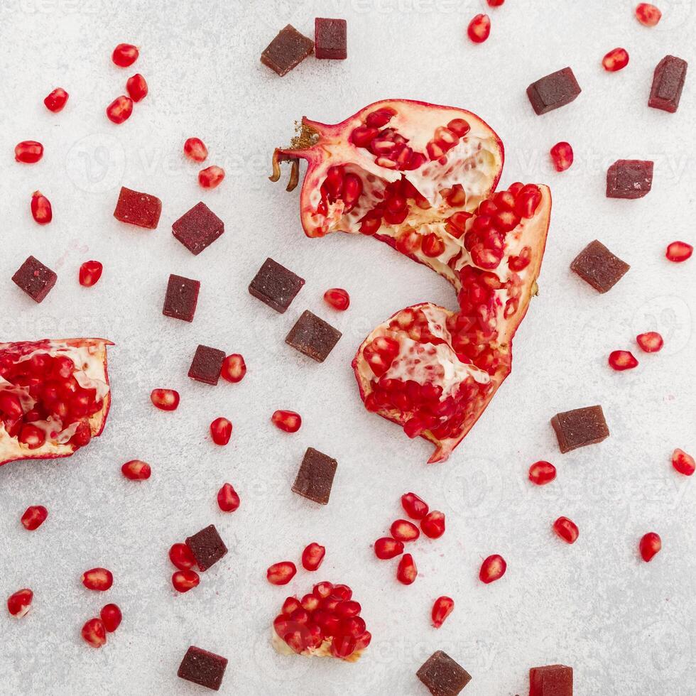Candied jelly with pomegranate fruits on table. Flat lay, top view. photo