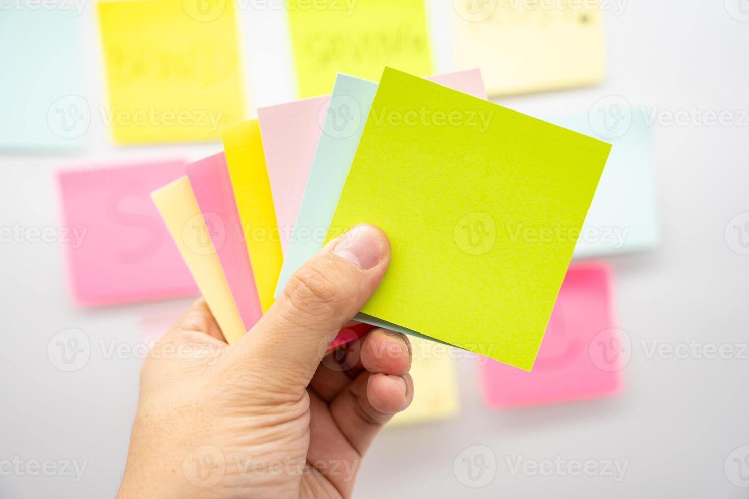 Hand holding blank colorful sticky note with Copy space. photo