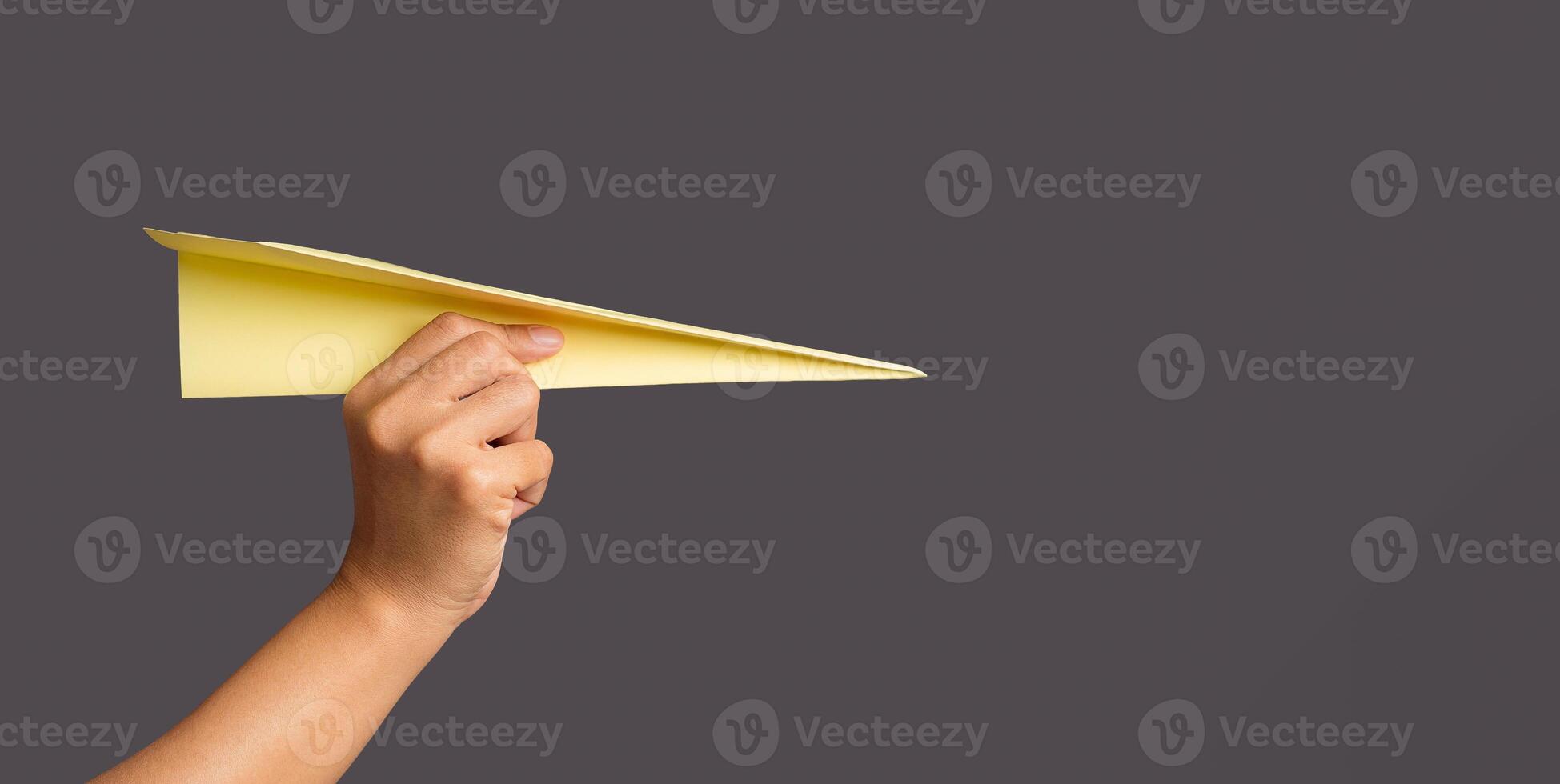 Business startup concept. Hand holding a yellow rocket paper on a gray background. Creative motivation with copy space photo